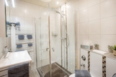 Das helle Bad mit einer ebenerdigen Dusche