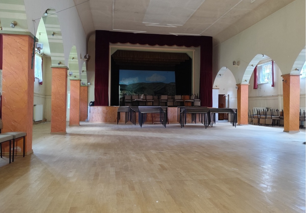 Heller Saal mit Bühne und Echtholzparkett