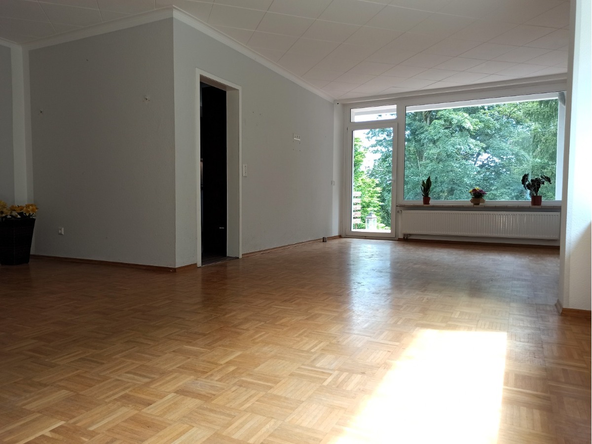 Das helle Wohnzimmer mit Parkett und Zugang zur Terrasse